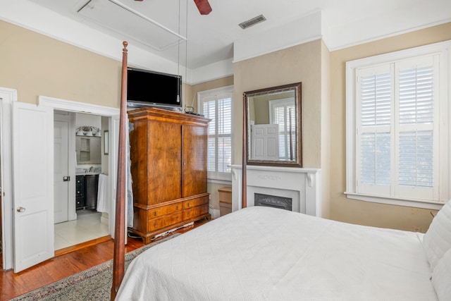 bedroom featuring ensuite bath, ceiling fan, and light hardwood / wood-style floors