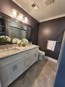 bathroom featuring visible vents, crown molding, toilet, double vanity, and a sink