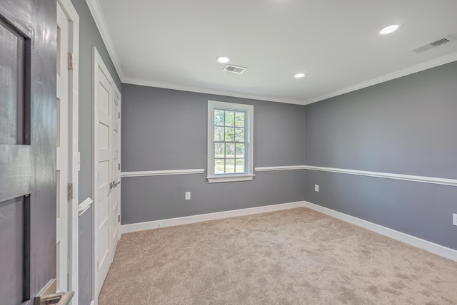 empty room with carpet flooring, baseboards, visible vents, and ornamental molding