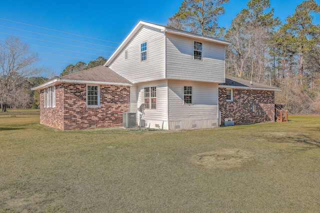 rear view of property featuring crawl space, a lawn, cooling unit, and brick siding