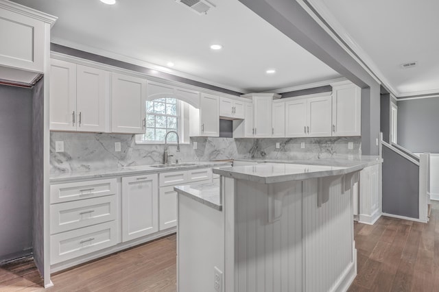 kitchen with a sink, visible vents, and wood finished floors