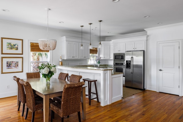 dining room with dark wood-type flooring, an inviting chandelier, and ornamental molding