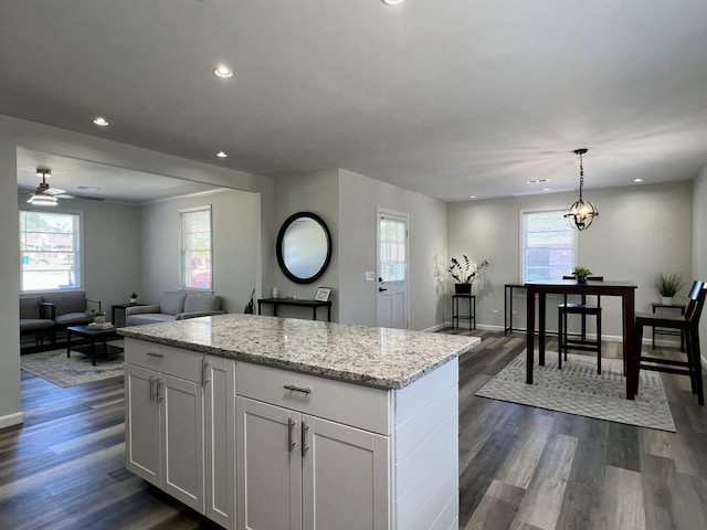 kitchen with dark wood-style flooring, a wealth of natural light, and a center island