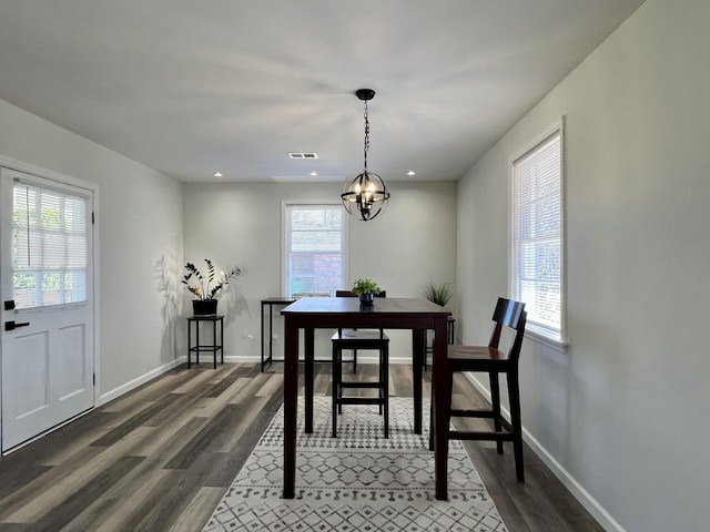 dining space with visible vents, an inviting chandelier, dark wood-type flooring, and baseboards