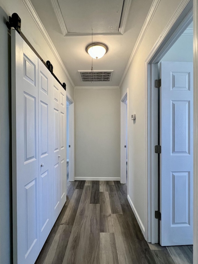 corridor with visible vents, attic access, ornamental molding, and dark wood finished floors