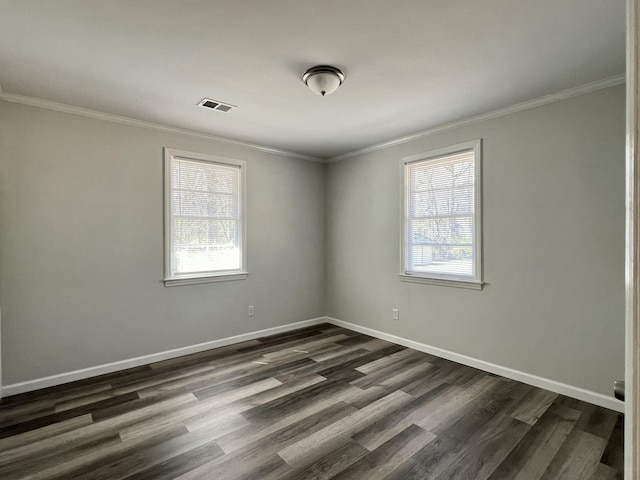 empty room with visible vents, crown molding, dark wood-type flooring, and baseboards