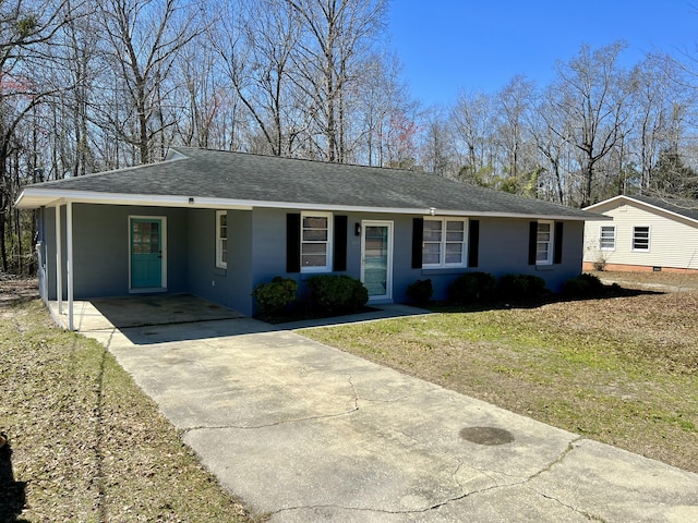 ranch-style home featuring a front lawn, roof with shingles, stucco siding, a carport, and driveway