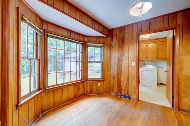 5322 Chantilly Ln, North Charleston, SC 29418 - unfurnished room with washer / clothes dryer, light wood-style flooring, baseboards, wooden walls, and plenty of natural light