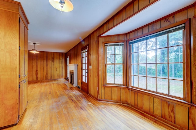 5322 Chantilly Ln, North Charleston, SC 29418 - unfurnished living room with light wood-style floors, plenty of natural light, a fireplace, wooden walls, and baseboards