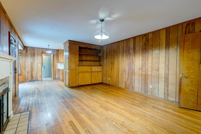 5322 Chantilly Ln, North Charleston, SC 29418 - unfurnished living room featuring wooden walls, light wood finished floors, and a fireplace