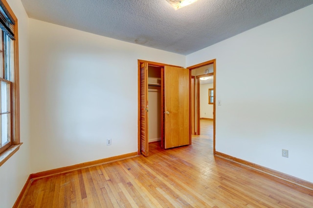 5322 Chantilly Ln, North Charleston, SC 29418 - unfurnished bedroom with light wood-type flooring, a closet, a textured ceiling, and baseboards