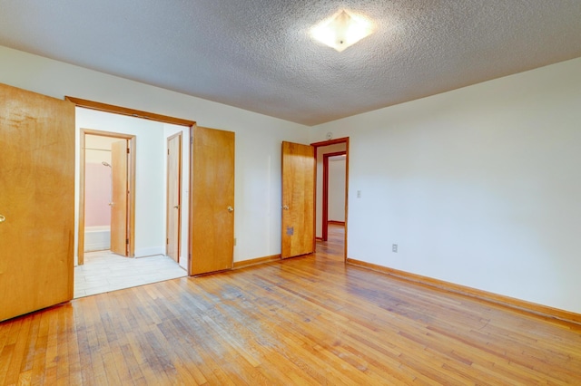 5322 Chantilly Ln, North Charleston, SC 29418 - unfurnished bedroom with light wood-style flooring, baseboards, and a textured ceiling