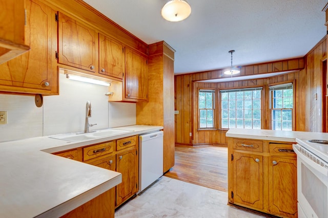 5322 Chantilly Ln, North Charleston, SC 29418 - kitchen featuring a sink, white appliances, wooden walls, and brown cabinets