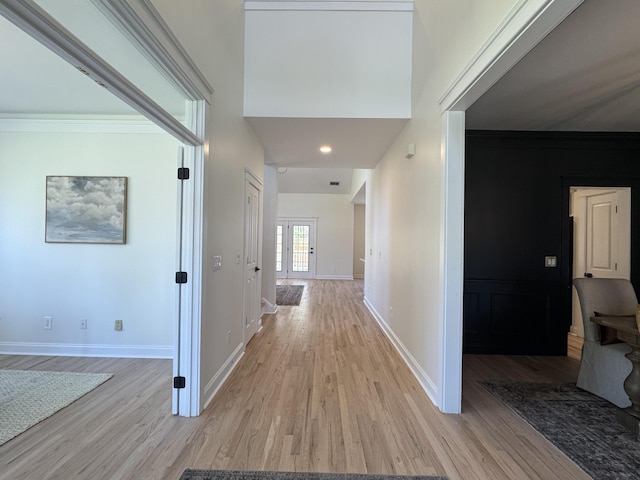 hallway with crown molding and light hardwood / wood-style flooring