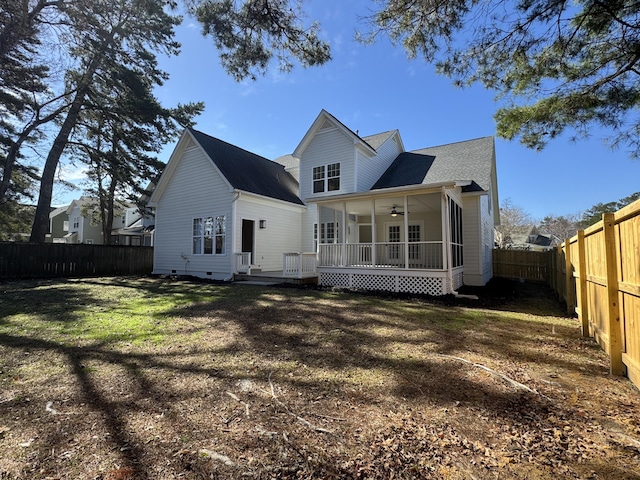 back of property with a yard and ceiling fan