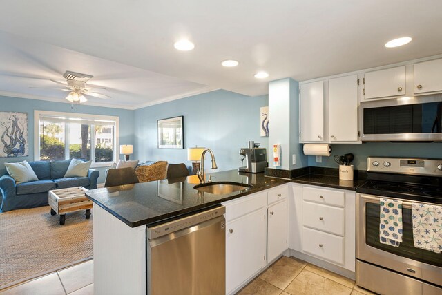 kitchen featuring sink, white cabinetry, light tile patterned floors, kitchen peninsula, and stainless steel appliances