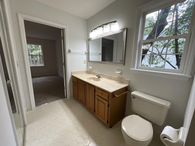 bathroom featuring toilet, tile patterned flooring, and vanity