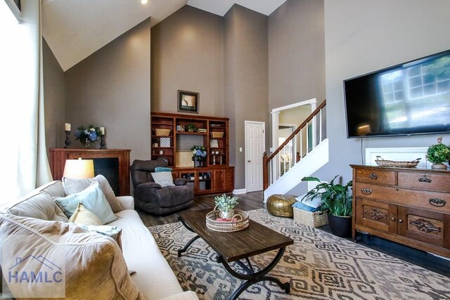 4800 Bay Branch Church Rd, Claxton, GA 30417 - living room featuring high vaulted ceiling, wood finished floors, stairs, baseboards, and healthy amount of natural light
