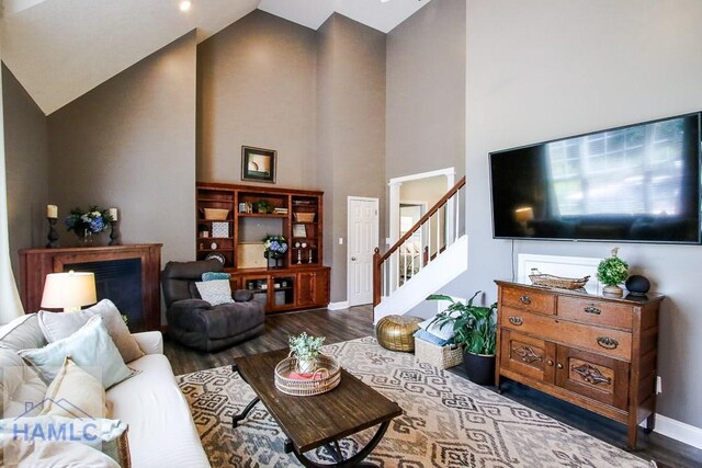 4800 Bay Branch Church Rd, Claxton, GA 30417 - living room featuring high vaulted ceiling, dark wood-style floors, ornate columns, stairs, and baseboards