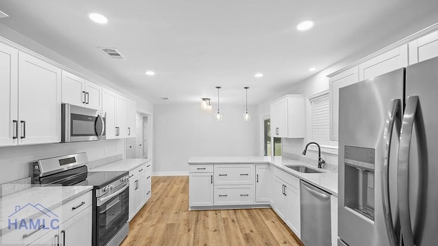 kitchen featuring kitchen peninsula, stainless steel appliances, white cabinetry, and sink