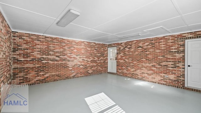 interior space featuring brick wall and concrete floors