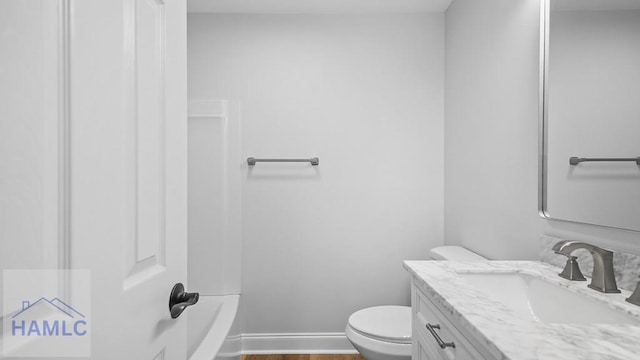 bathroom with hardwood / wood-style flooring, vanity, and toilet