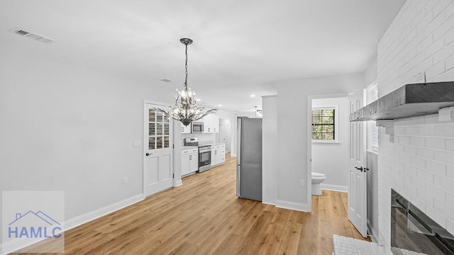 interior space featuring pendant lighting, white cabinets, light hardwood / wood-style flooring, a notable chandelier, and stainless steel appliances