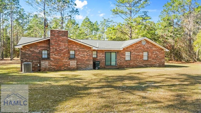 rear view of property with a lawn and central AC