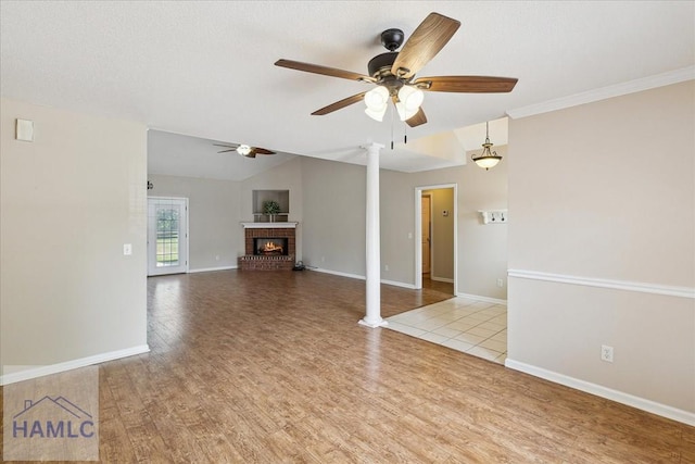 102 Penny Ln, Guyton, GA 31312 - unfurnished living room with a brick fireplace, ceiling fan, decorative columns, and wood finished floors