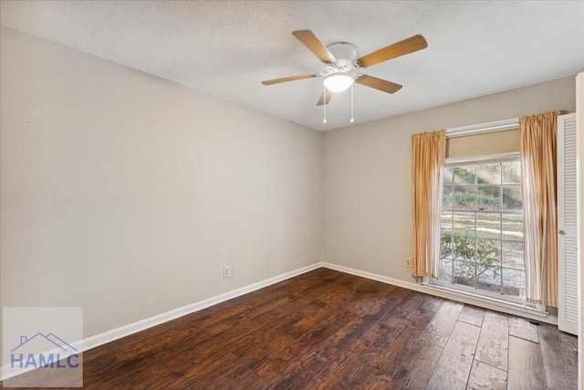 unfurnished room with ceiling fan and dark hardwood / wood-style flooring