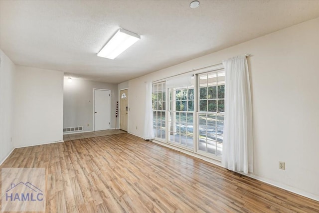 empty room with light hardwood / wood-style flooring