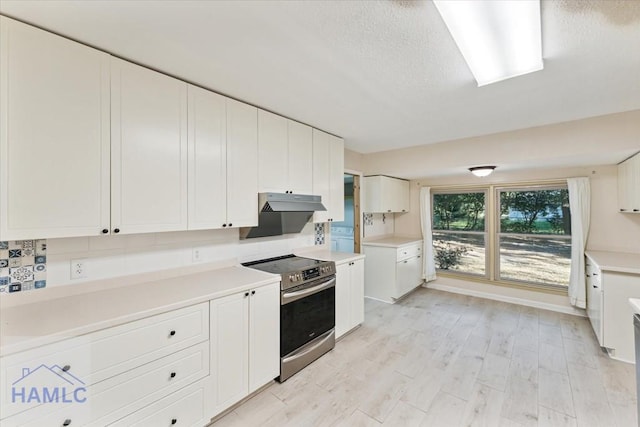 kitchen featuring white cabinets, tasteful backsplash, light hardwood / wood-style flooring, and stainless steel range with electric stovetop