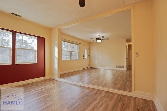 130 Melrose Pl, Rincon, GA 31326 - unfurnished room featuring visible vents, a healthy amount of sunlight, a ceiling fan, and wood finished floors