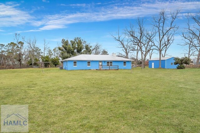 back of property with a lawn and a wooden deck