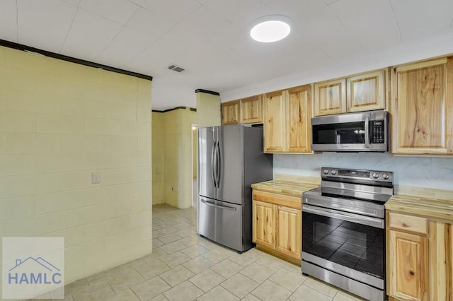 kitchen featuring light brown cabinetry and appliances with stainless steel finishes