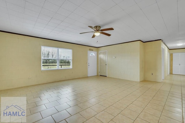 tiled spare room with ceiling fan and crown molding