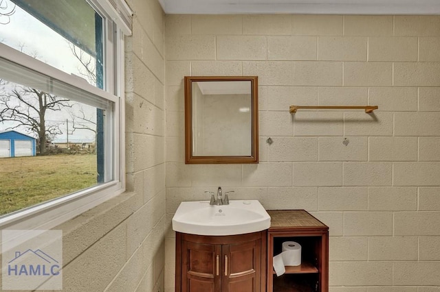 bathroom featuring vanity and brick wall