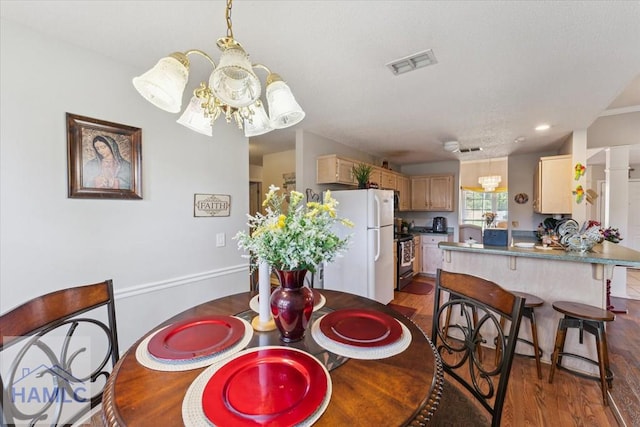 dining room featuring visible vents, an inviting chandelier, and dark wood-type flooring