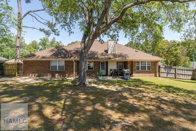 back of property featuring brick siding, fence, and a chimney