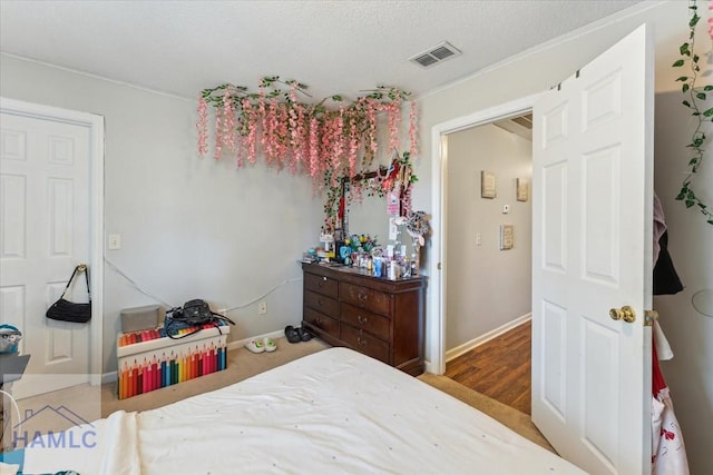 bedroom featuring baseboards, visible vents, and wood finished floors