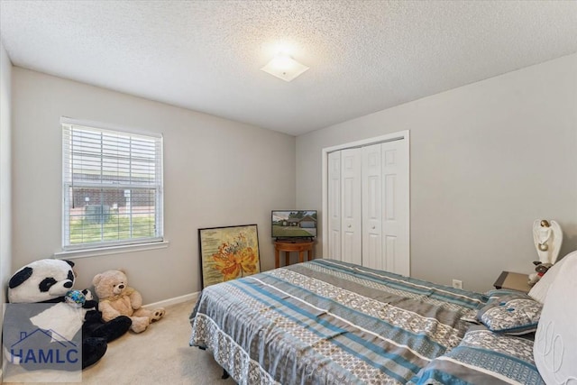 bedroom featuring a closet, baseboards, carpet flooring, and a textured ceiling