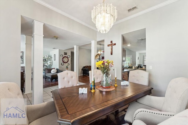 dining room with visible vents, crown molding, decorative columns, an inviting chandelier, and light tile patterned floors