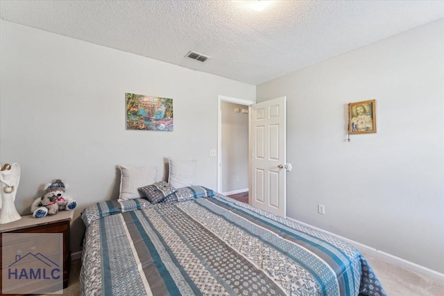 bedroom featuring visible vents, carpet, a textured ceiling, and baseboards