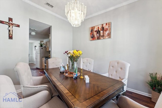 dining area with crown molding, a chandelier, baseboards, wood finished floors, and visible vents