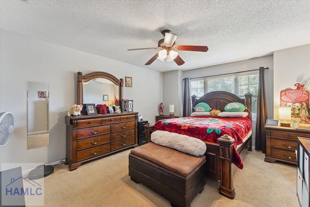 bedroom featuring light carpet, a ceiling fan, and a textured ceiling