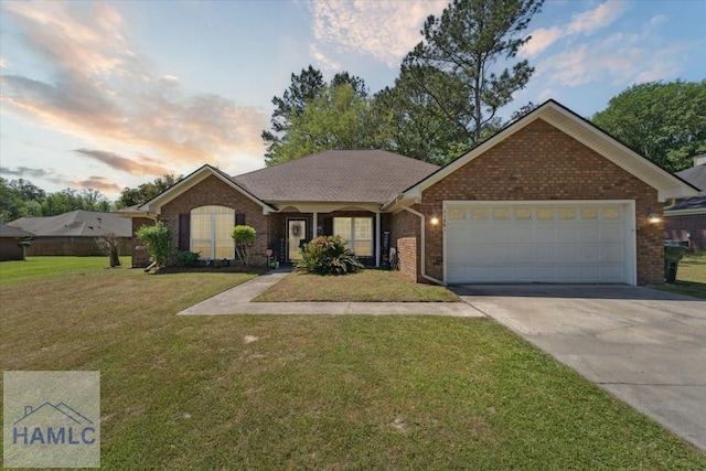 single story home featuring an attached garage, driveway, a front lawn, and brick siding