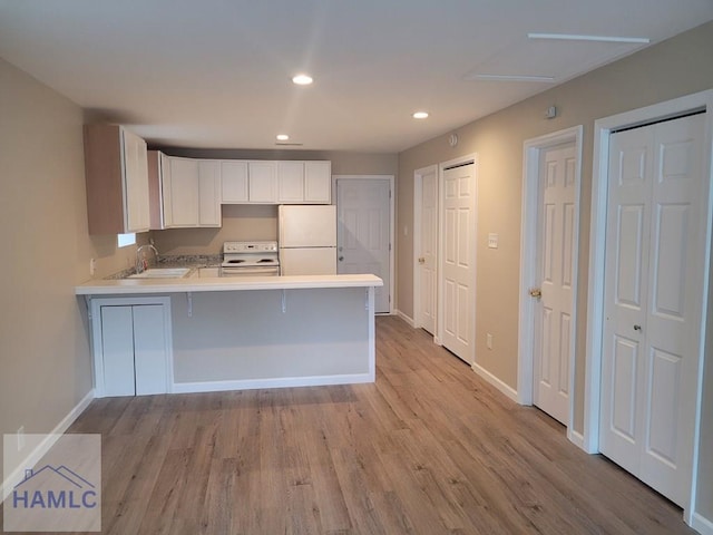2922 7th St, Columbus, GA 31906 - kitchen featuring white appliances, light wood finished floors, a peninsula, light countertops, and recessed lighting