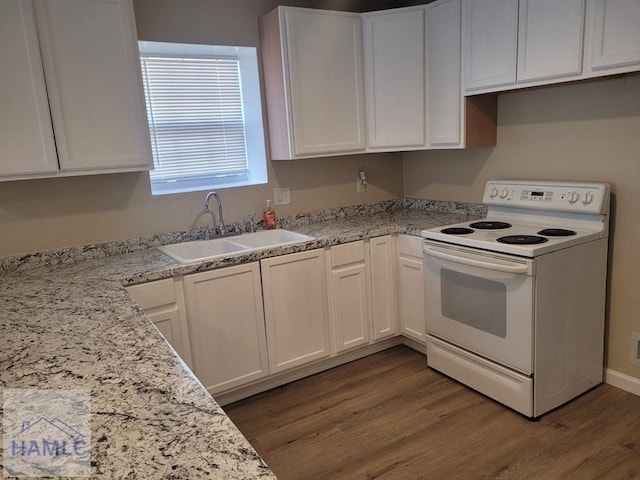 2922 7th St, Columbus, GA 31906 - kitchen with white range with electric cooktop, white cabinets, wood finished floors, and light stone counters