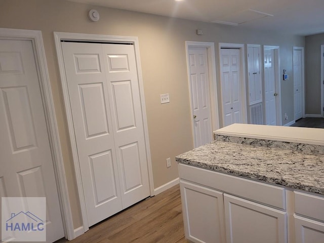 2922 7th St, Columbus, GA 31906 - kitchen featuring light wood-style flooring, white cabinets, and light stone counters