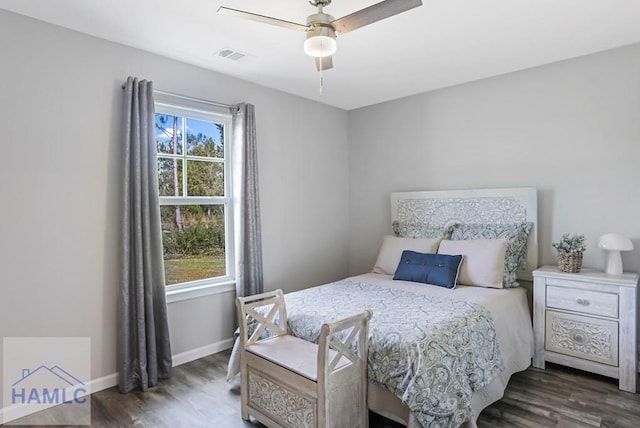 bedroom with visible vents, multiple windows, baseboards, and wood finished floors